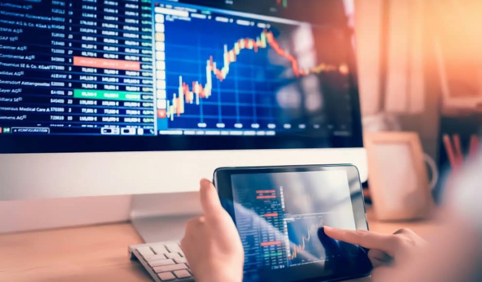 Woman Looking at Stocks on Computer and Tablet